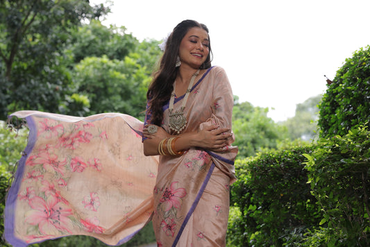 Woman wearing light beige floral print saree posing outdoors in traditional Indian ethnic attire