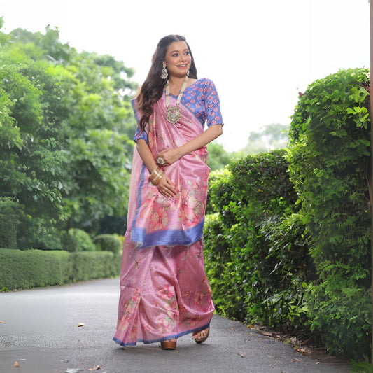 Woman wearing light pink floral print saree standing outdoors in elegant traditional Indian ethnic outfit