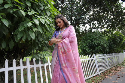 Woman wearing light pink floral print saree standing outdoors in elegant traditional Indian ethnic outfit