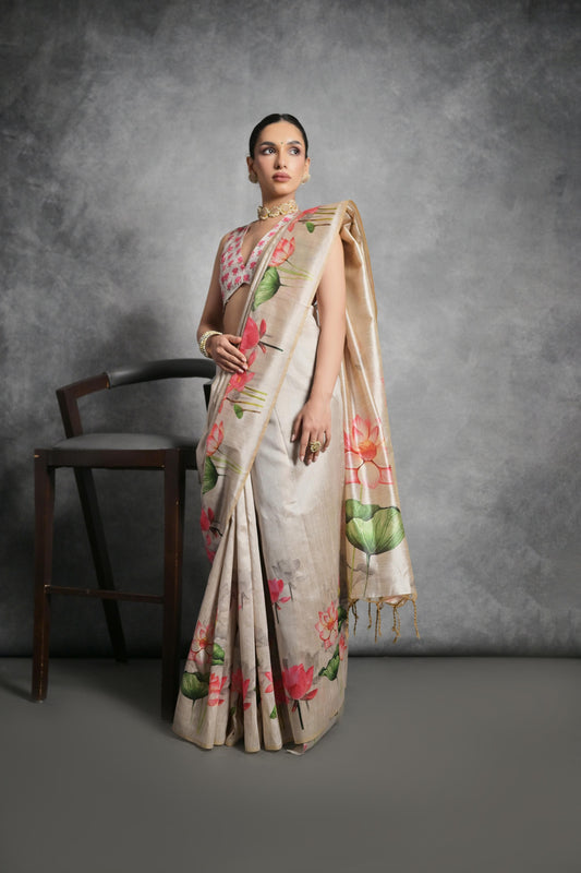 Woman wearing light beige floral printed saree posing outdoors in traditional Indian ethnic attire