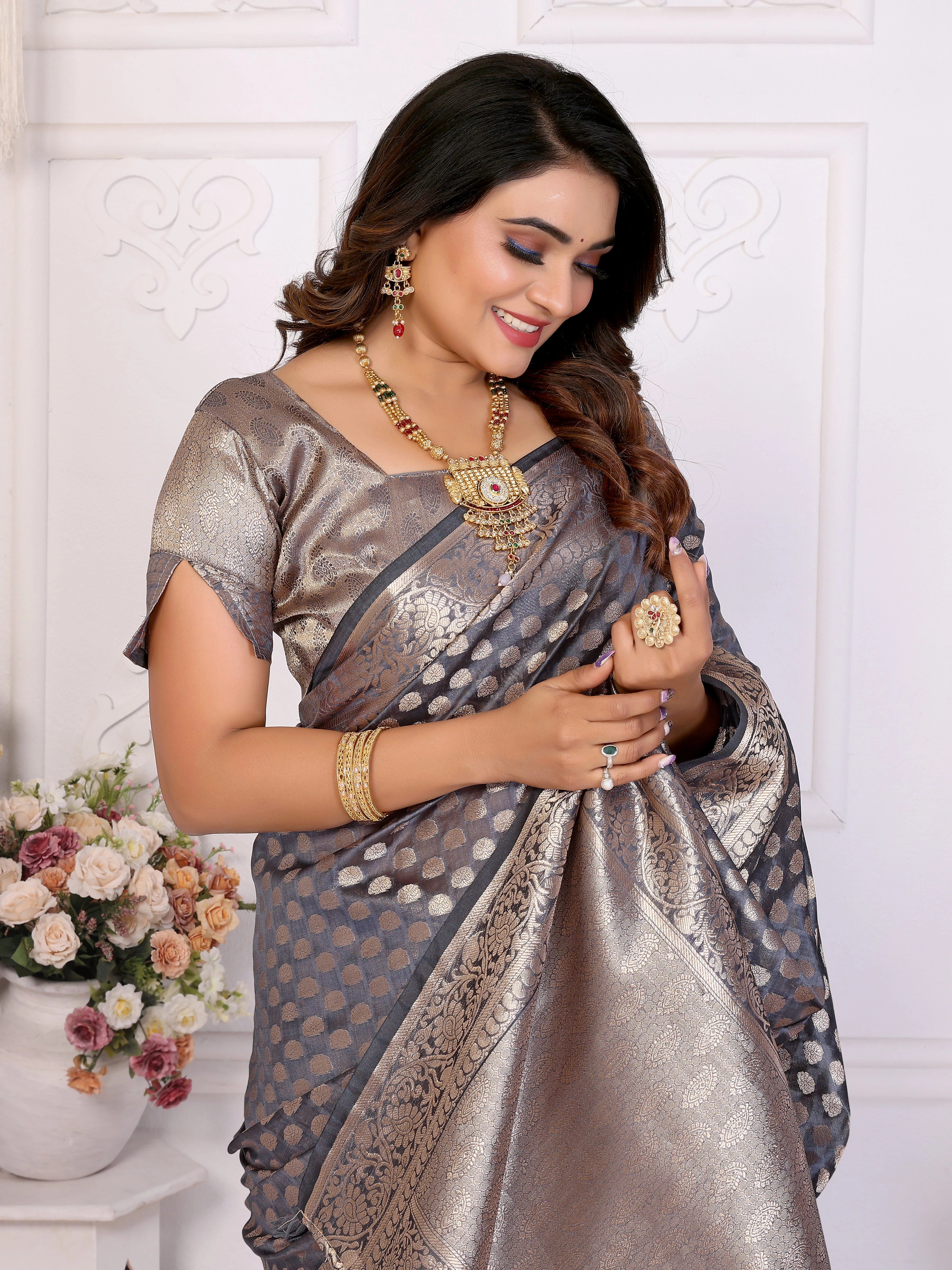 Woman wearing a traditional saree with jewelry against a white background