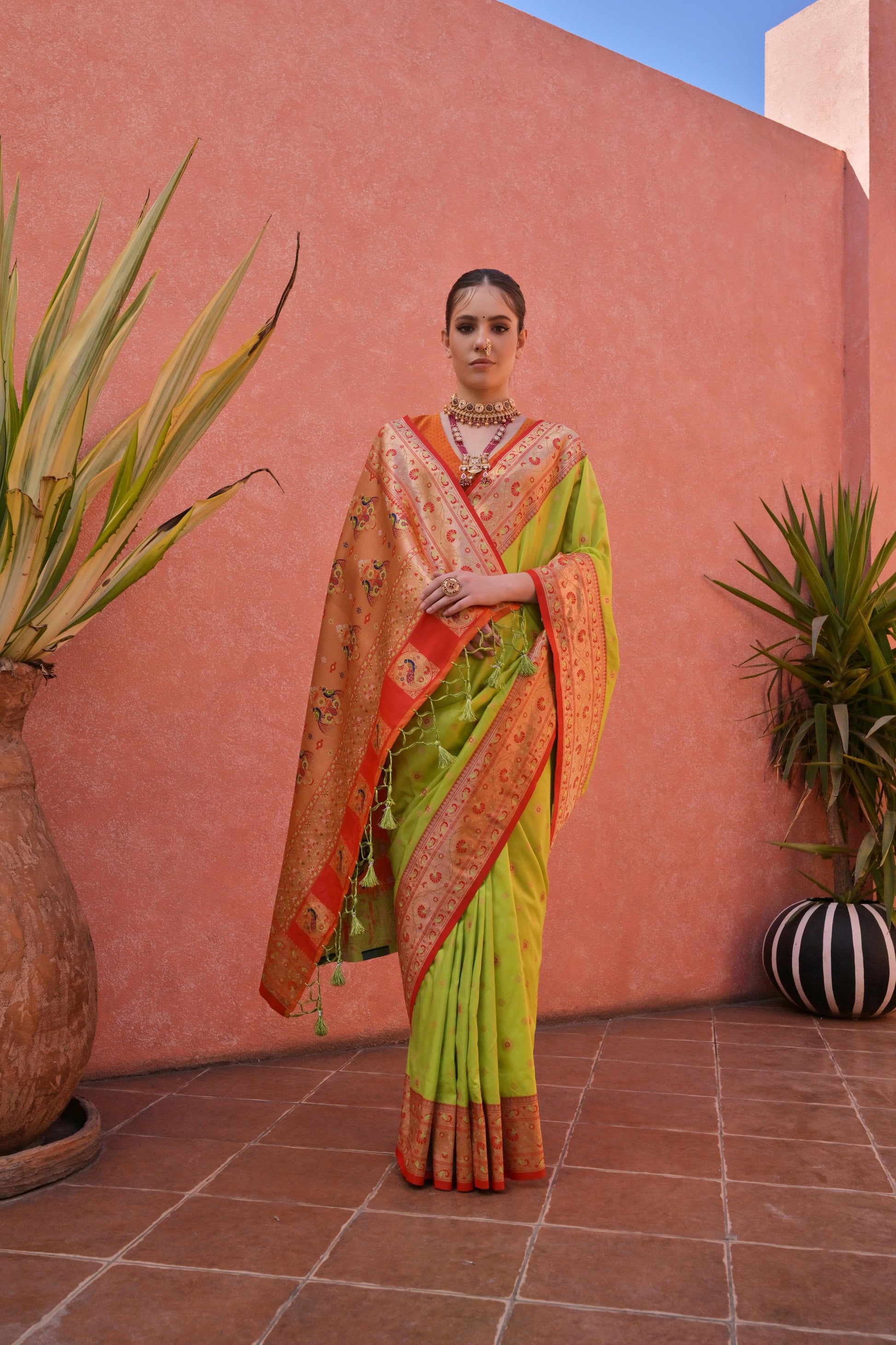 Vibrant green and red silk saree with traditional zari woven pallu, perfect for weddings and festivities.