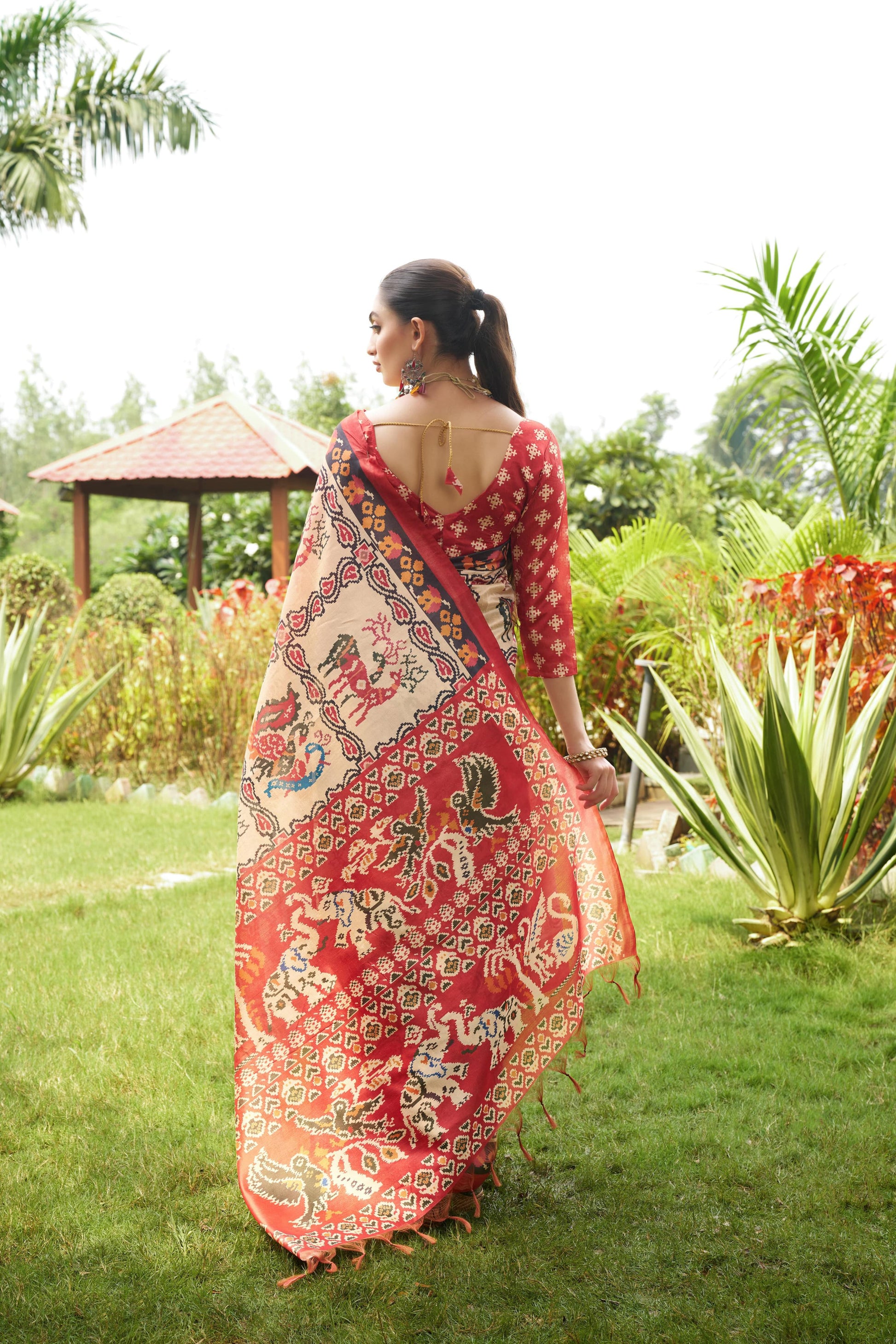 Light beige saree with Patola print seen from behind outdoors