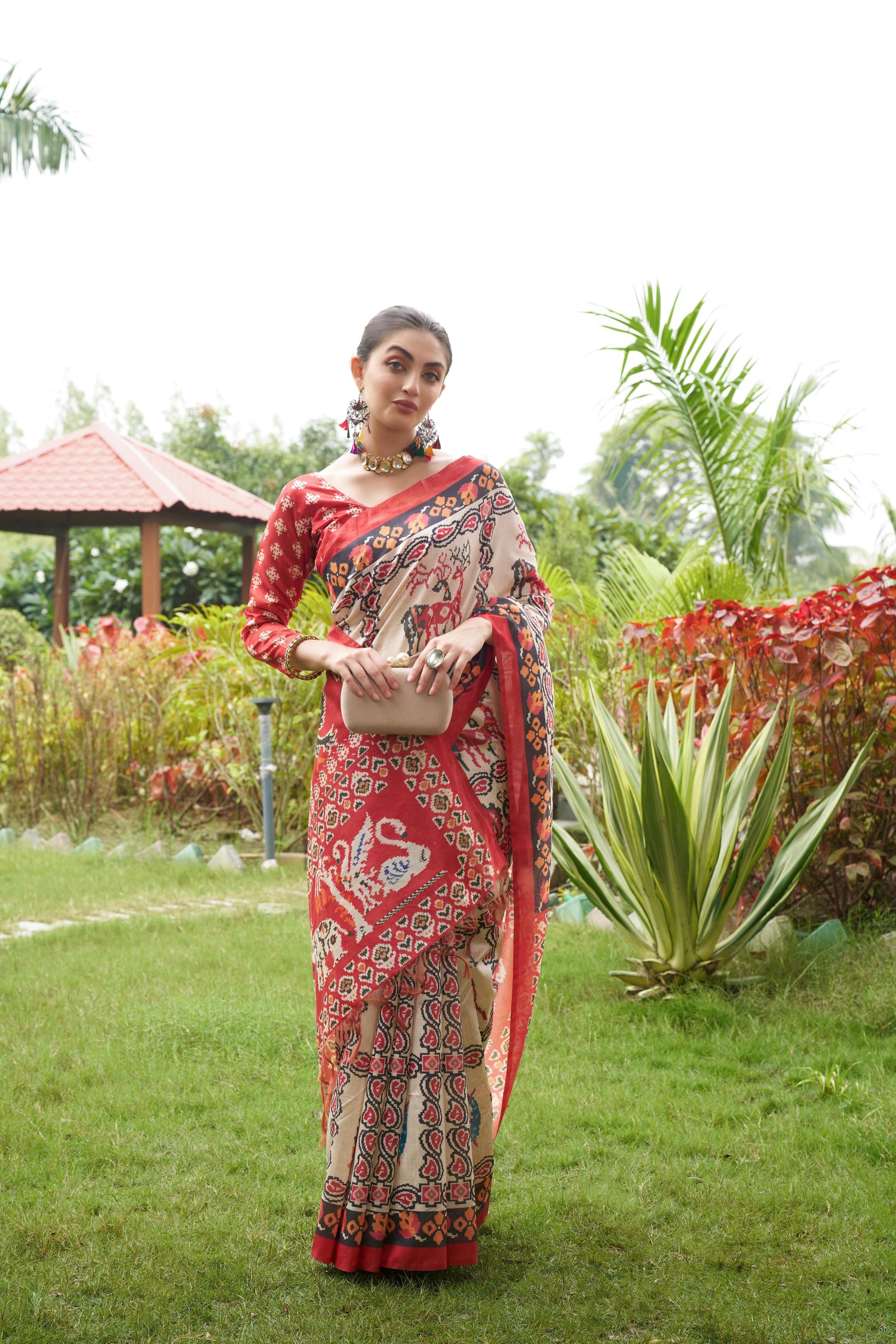 Light beige saree with Patola print in a garden outdoors
