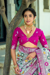 Close-up of woman in light gray zari work saree with magenta blouse and traditional gold jewelry in ethnic style