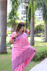 Woman in light pink traditional weaving saree showcasing elegant ethnic style in garden background