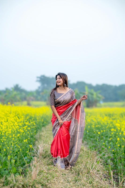 Woman wearing red Madhubani print saree posing outdoors in traditional Indian ethnic wear