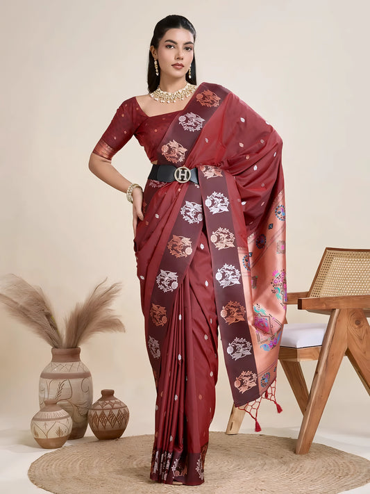 Woman wearing a maroon Banarasi silk saree with intricate floral motifs and a contrasting copper border, paired with a matching blouse and statement pearl necklace, elegantly posing beside a wooden chair in a minimalist studio setting with neutral decor, ceramic vases, and pampas grass.

Related
maroon-banarasi-silk-saree-floral-border-modern-studio
Woman in a maroon Banarasi silk saree with floral motifs and gold border, posing in a minimalist studio setting.