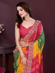 Woman wearing a colorful saree with a pink blouse against a dark background