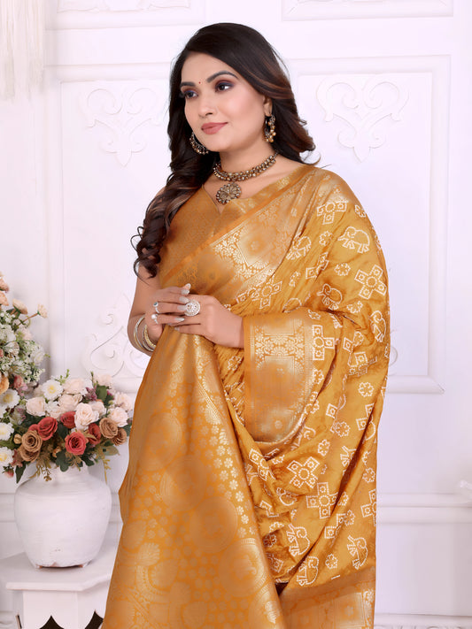 Woman wearing a mustard yellow Banarasi silk saree featuring intricate gold traditional motifs and a shimmering woven border, paired with a matching blouse and statement jewelry. She poses elegantly in a classic white room adorned with ornate wall panels and decorative vases overflowing with pastel and white artificial flowers.