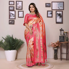 Woman in a pink saree standing in a room with decorative elements.