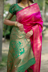 Close-up of pink zari work saree highlighting detailed pallu, floral green border, and traditional blouse design with gold jewelry