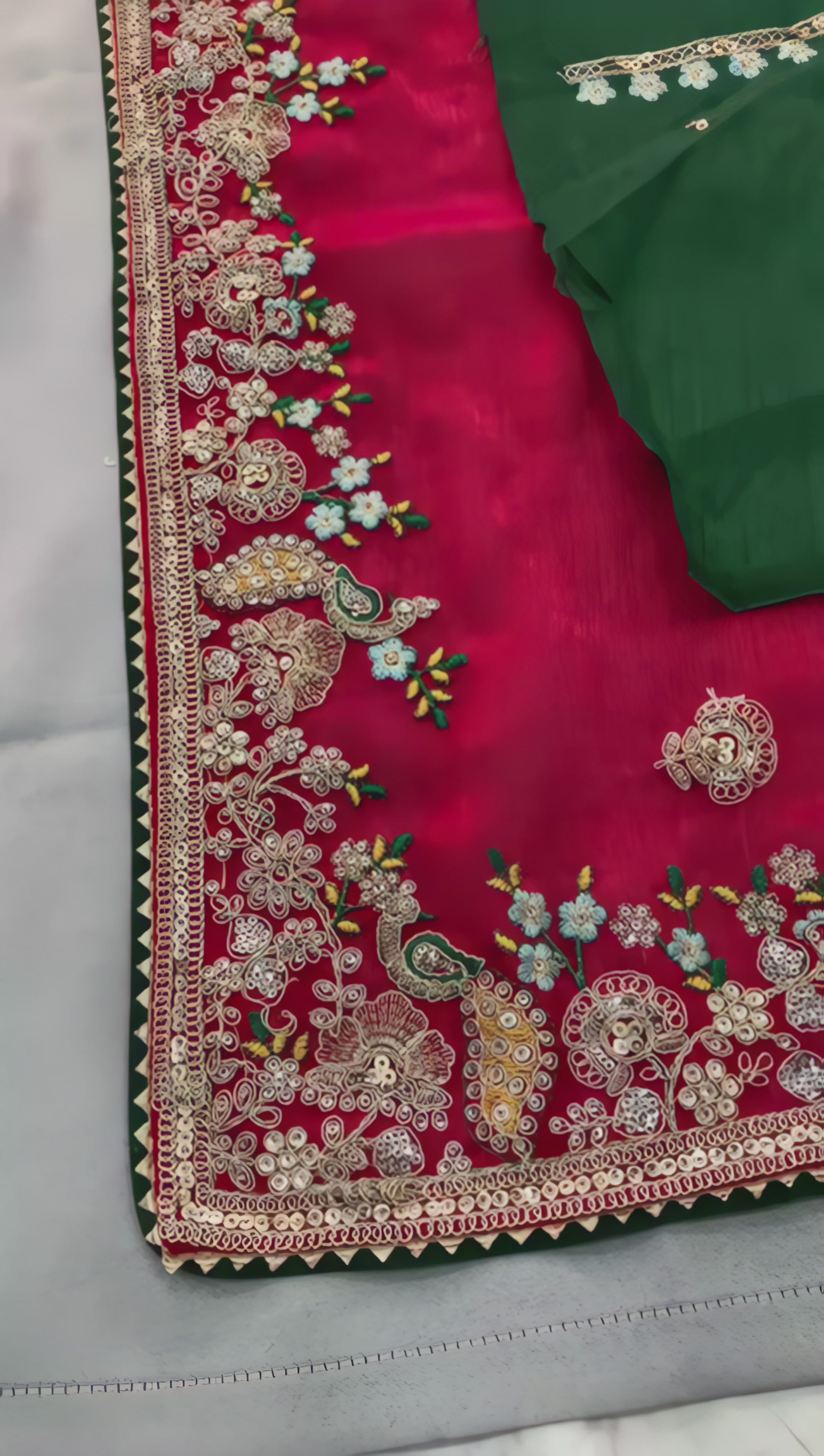 woman-pink-embroidered-saree-green-blouse-floral-border-modern-chair-background