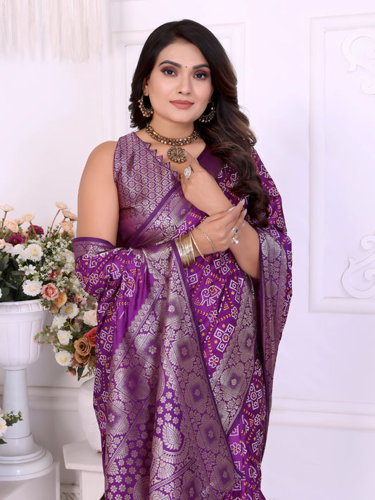 Woman wearing an elegant purple Banarasi bandhani saree adorned with intricate silver zari border and traditional woven motifs, paired with a matching sleeveless blouse and statement jewelry. She poses gracefully in a classic white room decorated with ornate wall panels and vases filled with pastel and rose-toned artificial flowers.