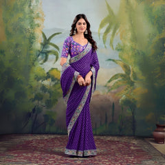 Woman wearing purple saree with floral embroidered border and matching blouse in studio backdrop