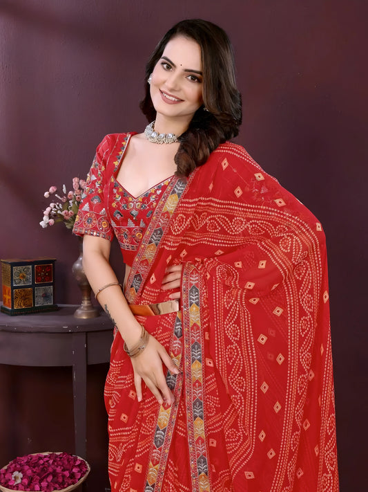 Woman wearing a red bandhani print saree with a contrast patterned border and matching blouse, styled with a choker necklace in an indoor studio setup, Indian ethnic wear product photo