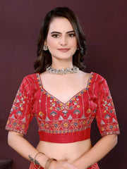Woman wearing a red traditional outfit with intricate patterns on a dark background