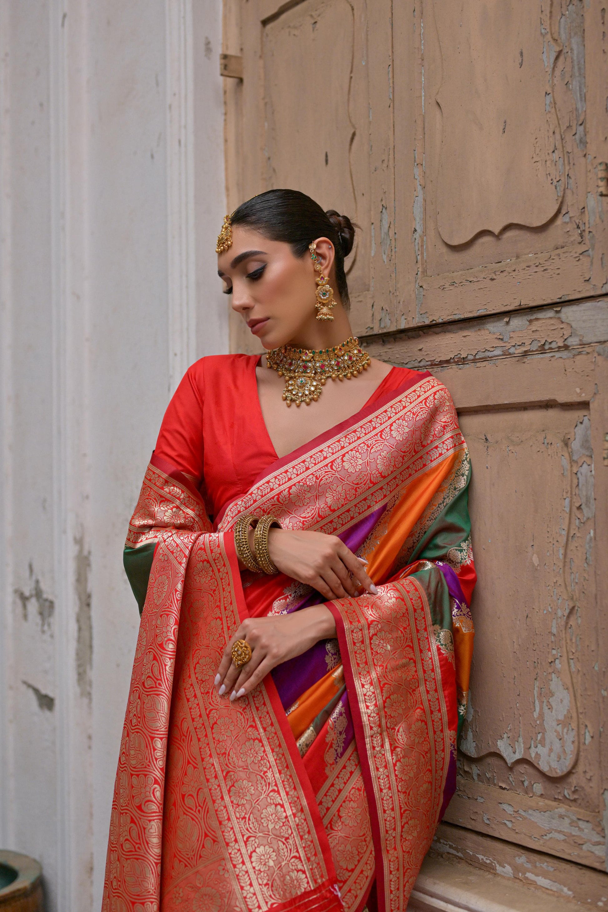 Close up of red saree with Kadwa style weaving and multicolor design