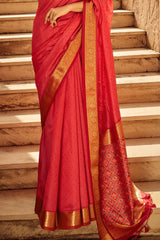 Close-up view of red saree featuring intricate zari work on the pallu and golden border, showcasing traditional Indian craftsmanship