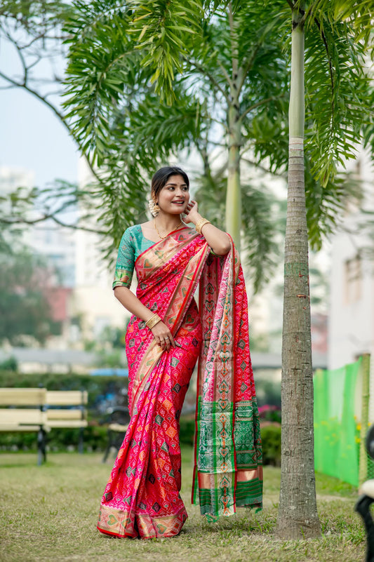 Woman wearing a red saree with intricate zari work and traditional patterns
