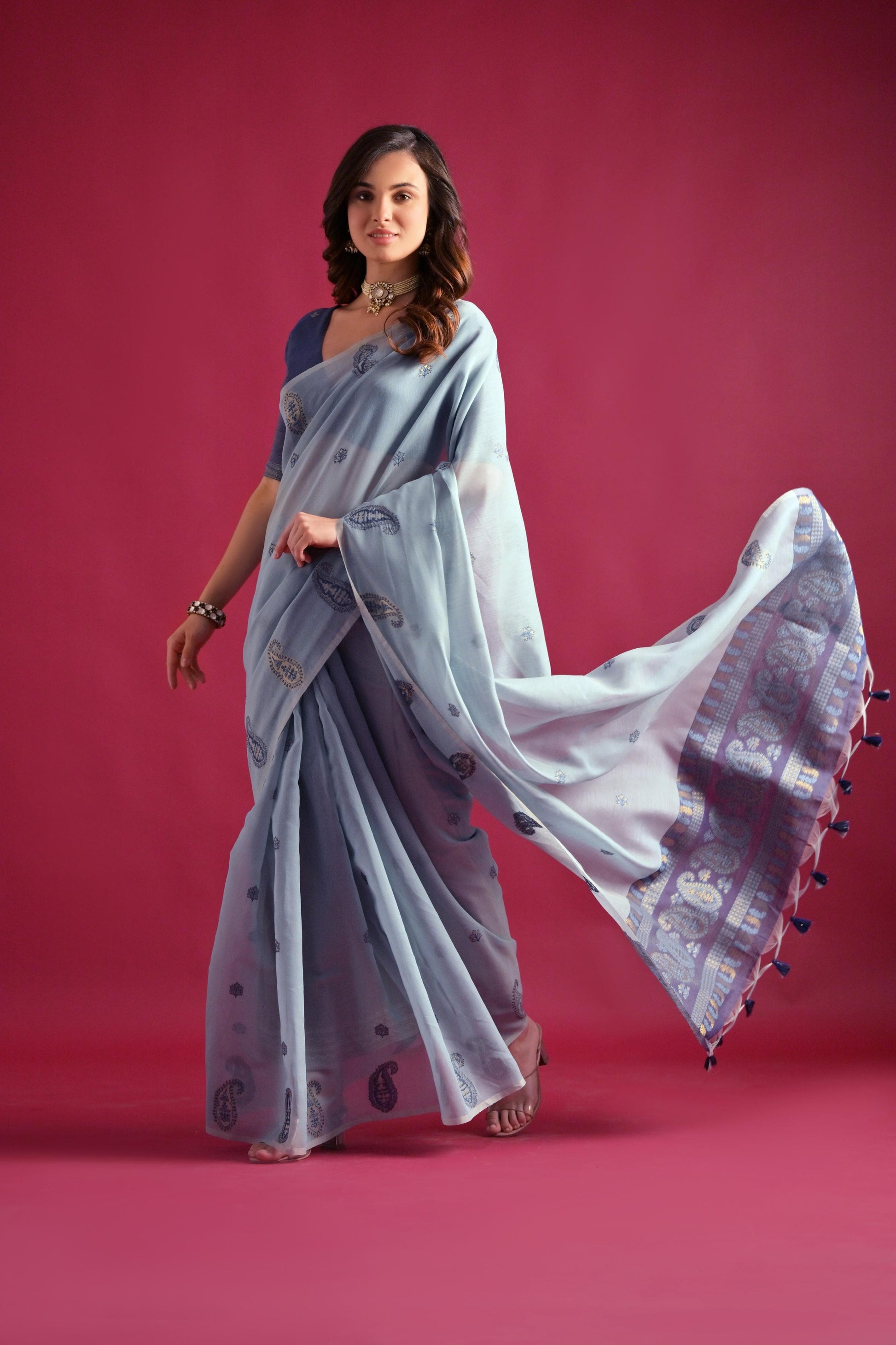 Woman wearing blue gray Resham weaving saree posing outdoors in traditional Indian ethnic attire