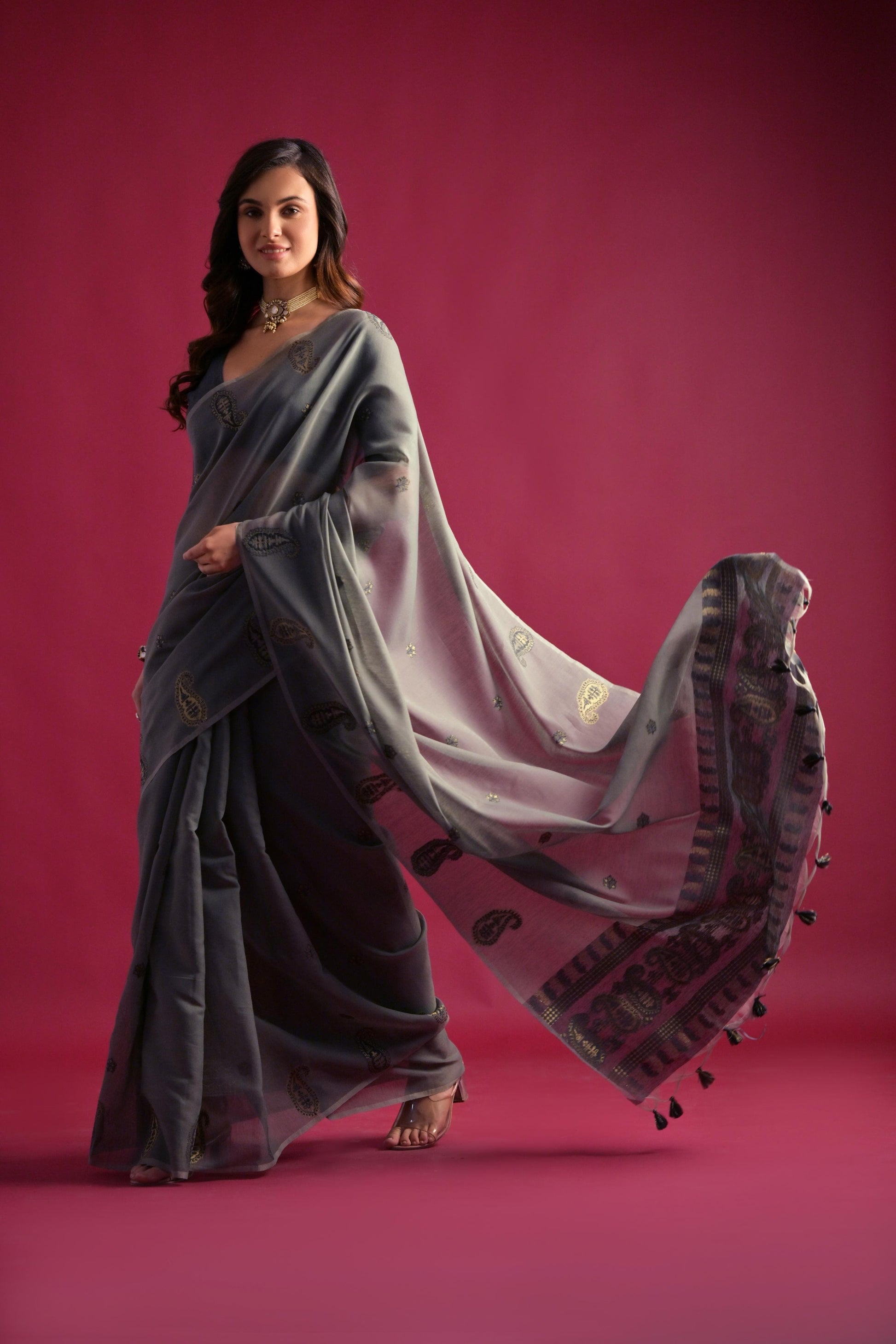 Woman wearing gray Resham weaving saree standing outdoors in elegant traditional Indian ethnic attire