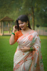 Woman wearing orange resham weaving saree with floral patterns in outdoor garden setting