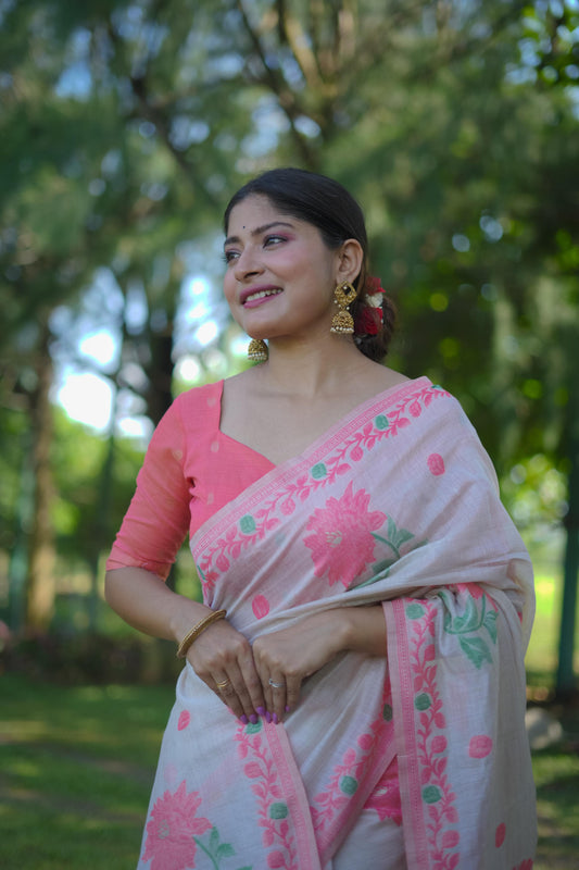 Woman wearing a pink saree with resham weaving design and golden earrings