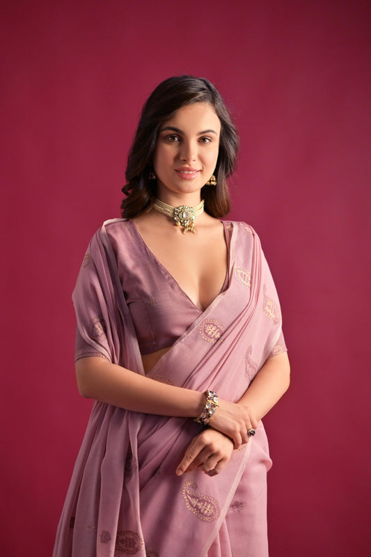 Woman wearing soft pink Resham weaving saree posing outdoors in traditional Indian ethnic attire