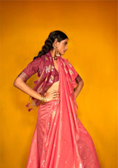 Model in tulip pink zari work silk saree posing in side view with ethnic jewellery against mustard yellow background