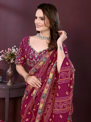 Woman wearing a wine color digital print saree with embroidery work and a contrast patterned border, paired with a matching blouse in an indoor studio product image, Indian ethnic wear