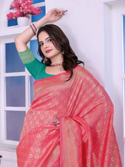 A woman models a striking Pink Banarasi Silk Saree with dense all-over gold Zari weaving. The pallu provides a dramatic contrast in sea green with heavy gold weaving. She wears a sea green blouse and gold jewelry, and has flowers in her hair.
