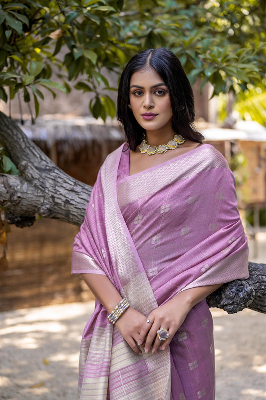 Woman wearing lavender pink Zari weaving saree posing outdoors in elegant traditional Indian attire