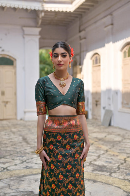 Woman wearing deep green Zari work saree posing outdoors in traditional Indian ethnic attire
