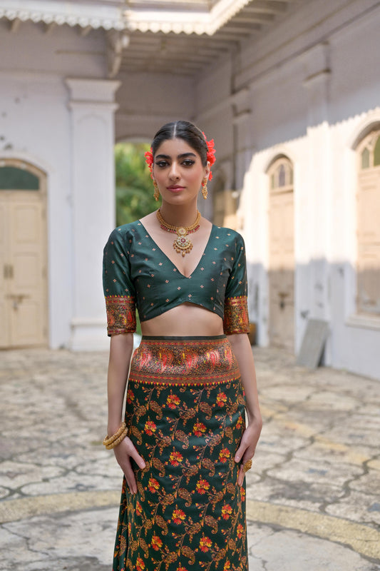 Woman wearing deep green Zari work saree posing outdoors in traditional Indian ethnic attire